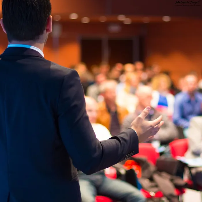 Conférencier de la Méthode TARGET® animant une conférence sur la préparation mentale et l’optimisation de la performance devant un large public.